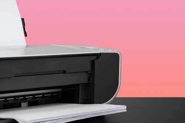 Compact home laser printer against pink background