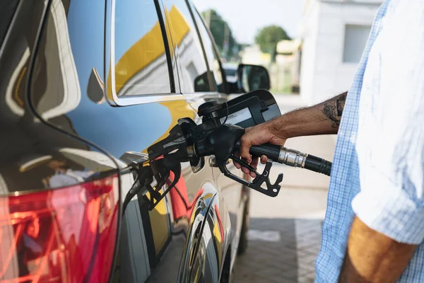 Человек, заправляющий бензин в машине на заправке — стоковое фото