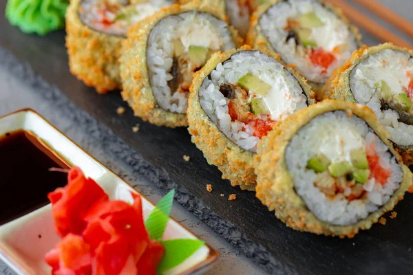 Rollo tempura de sushi japonés servido en plato de piedra negra — Foto de Stock