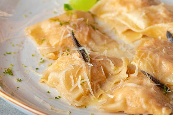 Italiensk maträtt ravioli med parmesan i en tallrik — Stockfoto