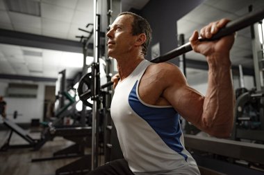 Spor salonundaki yaşlı kaslı bir adamın portresi.