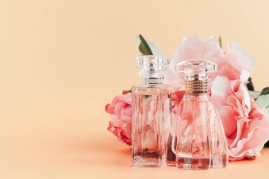Hafif kumaş üzerinde çiçekler olan bir şişe parfüm.