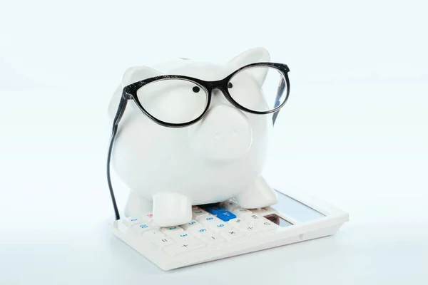 Piggy Bank med miniräknare på vit bakgrund — Stockfoto