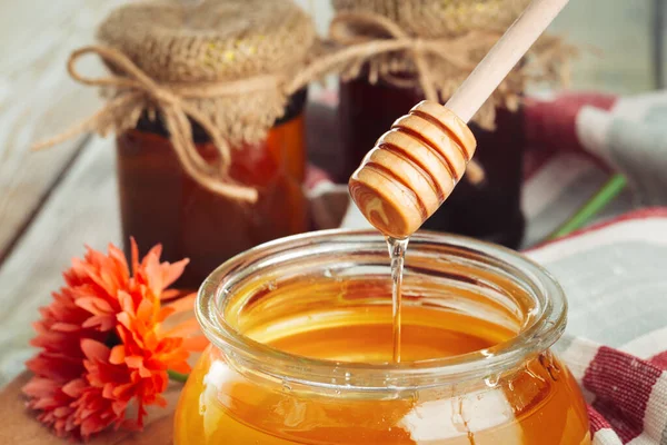 Honey background. Sweet honey in glass jar on wooden background. — Stock Photo, Image