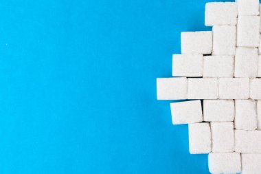 Parlak mavi arkaplanda beyaz şeker küpleri