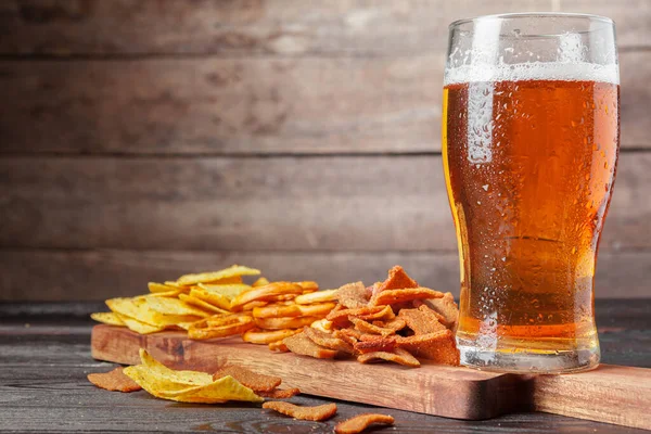 나무 탁자 위에 맥주와 간식을 놓고. 너트, 칩, 프레첼 — 스톡 사진