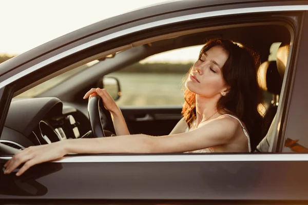 Schöne lächelnde Frau am Steuer ihres Autos am Morgen — Stockfoto