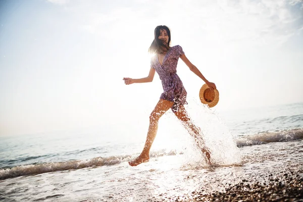 Retrato de una joven caminando por la playa al amanecer — Foto de Stock