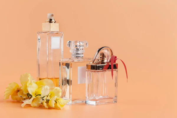 Parfém láhve s květinami okvětní lístky na béžové pozadí — Stock fotografie