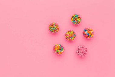 Şeker parçacıkları, pasta, dondurma ve pembe arka planda kurabiyeler için süsleme