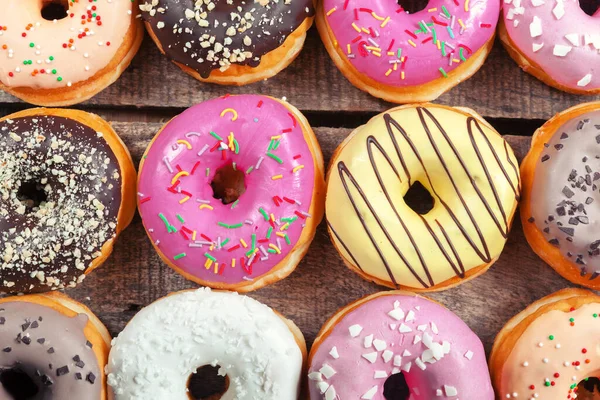 Geglazuurde donuts op houten ondergrond — Stockfoto