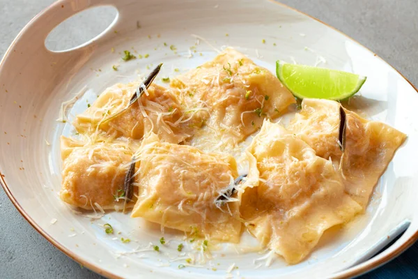 Italiaanse schotel ravioli met parmezaanse kaas in een bord — Stockfoto