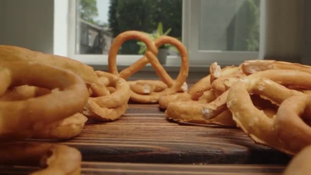 Zoom em vídeo de montão de mini biscoitos salgados pretzel na placa de madeira — Vídeo de Stock