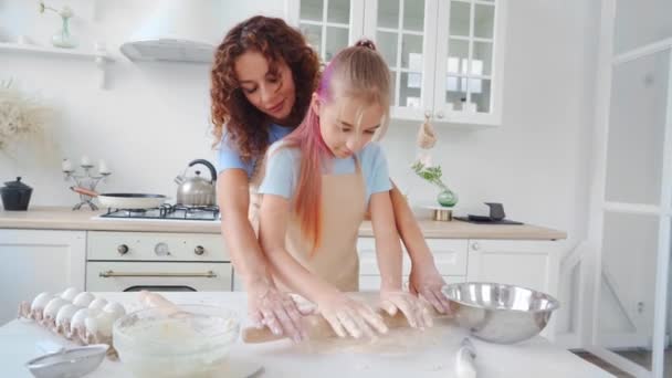 Moeder en haar tienerdochter bereiden samen deeg voor pizza of koekjes in de keuken — Stockvideo