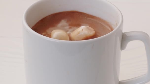 Mini pianki wpadające do filiżanki napoju kakaowego, zbliżenie — Wideo stockowe
