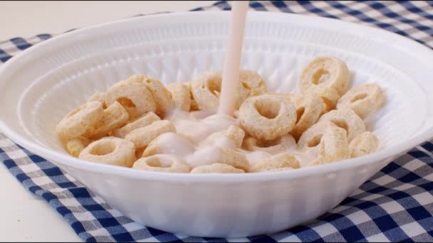 Lait versé dans un bol avec des flocons de céréales colorés pour le petit déjeuner — Video