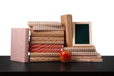 Masaüstünde beyaz arkaplana karşı kitap ve elma yığını
