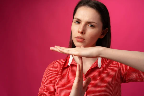 Pembe arka planda reddedilme hareketi gösteren çekici genç bir kadın. — Stok fotoğraf