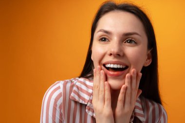 Şok olmuş ve şaşkın kız pembe arka planda çığlık atıyor.