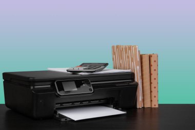 Masanın üzerinde yeşil arkaplana karşı ev lazer yazıcısı