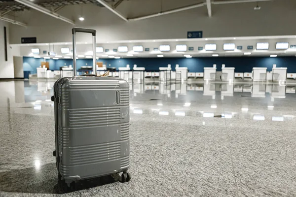 Mala de viagem cinza no corredor do aeroporto vazio — Fotografia de Stock