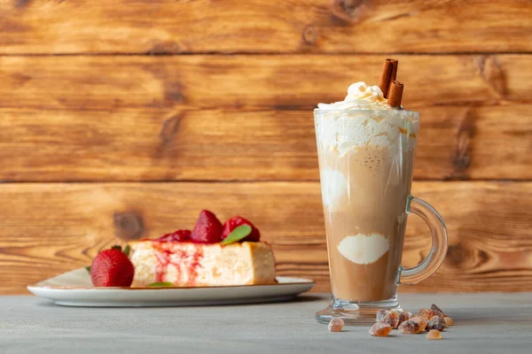 Glas latte kaffe och bit jordgubbscheesecake på grått bord — Stockfoto