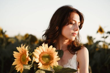 Ayçiçeği tarlasında güzel bir genç kadının portresi.