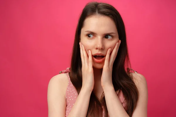 Шокована і здивована дівчина кричить на рожевому фоні — стокове фото