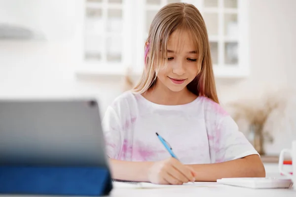 Homeschooled poco joven estudiante teniendo clase en línea usando tableta digital —  Fotos de Stock