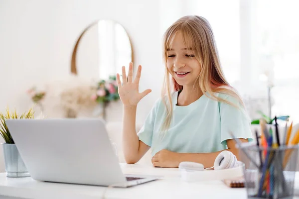 Chica joven usando el ordenador portátil para la tarea en casa —  Fotos de Stock