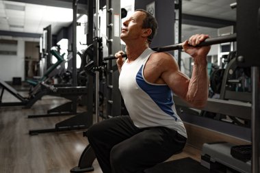 Spor salonundaki yaşlı kaslı bir adamın portresi.