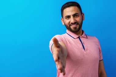 Olumlu Arap adam tokalaşıyor ve selamlıyor.