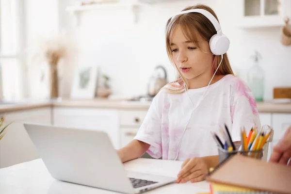 Chica joven usando el ordenador portátil para la tarea en casa —  Fotos de Stock