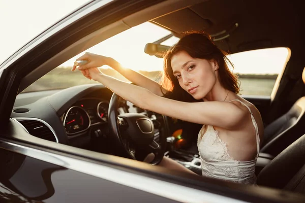 Schöne lächelnde Frau am Steuer ihres Autos am Morgen — Stockfoto