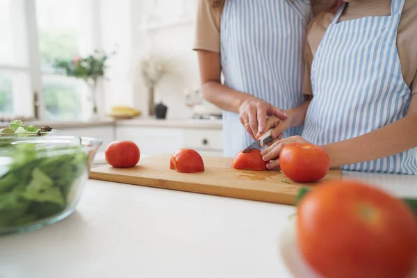 Close-up de uma mulher e menina cortando legumes para salada na cozinha — Fotografia de Stock