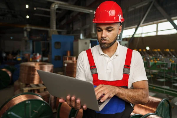 Ipari dolgozó laptoppal, kábelgyártó üzemben — Stock Fotó