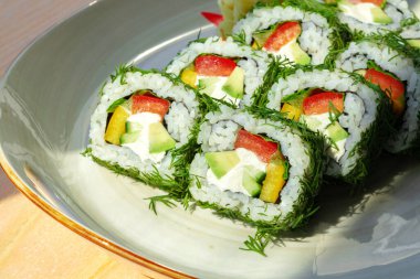 Ahşap arka planda dereotlu ve sebzeli vejetaryen suşisi rulosu.