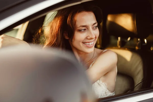 Schöne lächelnde Frau am Steuer ihres Autos am Morgen — Stockfoto
