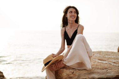 Sahilde gülümseyen genç kadın portresi.