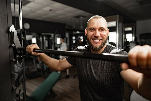 Vidám mosolygós férfi testépítő áll a tornateremben — Stock Fotó
