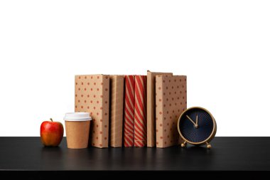 Alarm saati, beyaz arkaplan karşısında kitap yığını ve fincan