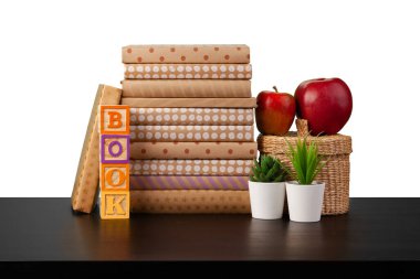 Masaüstünde beyaz arkaplana karşı kitap ve elma yığını