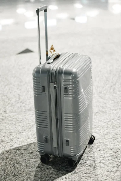Szara walizka podróżna w pustym holu lotniska — Zdjęcie stockowe
