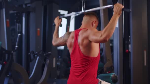 Masculino entrenamiento espalda músculos haciendo tira de ejercicio de peso en un gimnasio — Vídeo de stock