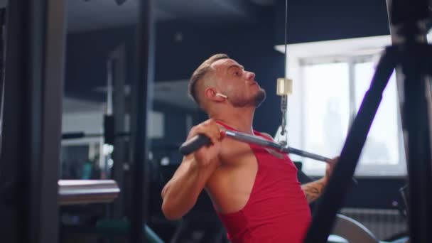 Masculino entrenamiento espalda músculos haciendo tira de ejercicio de peso en un gimnasio — Vídeo de stock