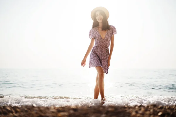 stock image Lonely young woman walks on the seashore at sunset