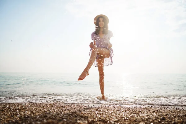 Portrait of young woman walking on the beach on sunrise — Stock Photo, Image