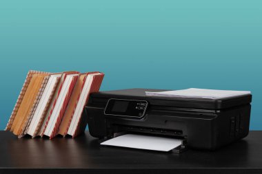 Masanın üzerinde yeşil arkaplana karşı ev lazer yazıcısı