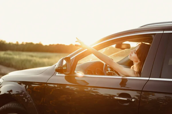 Schöne lächelnde Frau am Steuer ihres Autos am Morgen — Stockfoto