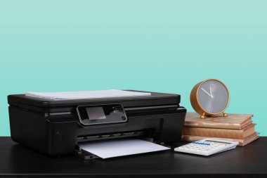 Masanın üzerinde yeşil arkaplana karşı ev lazer yazıcısı